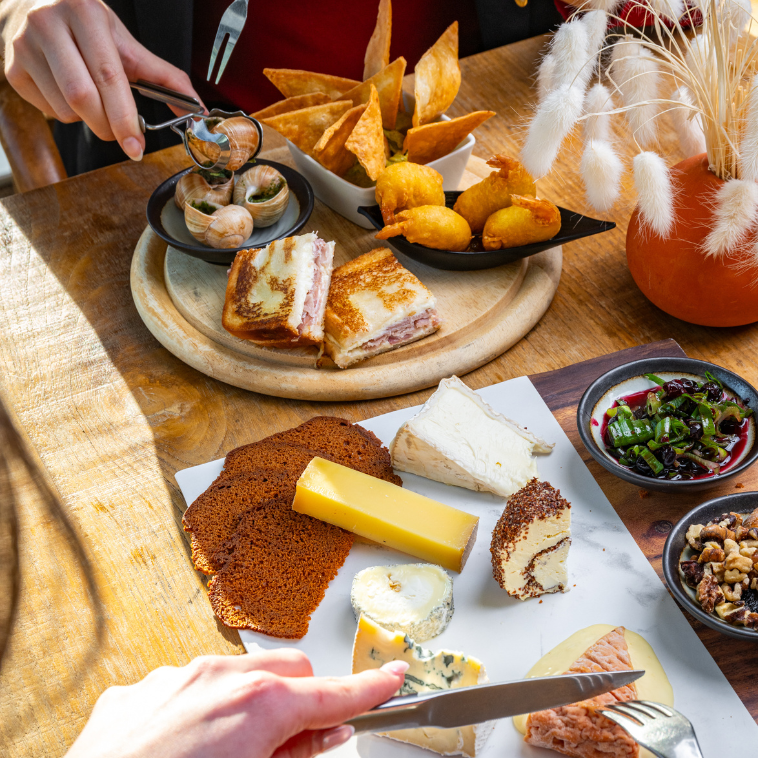 Chef du restaurant M7 assis en terrasse, devant une boisson estivale et des amuse-bouches.